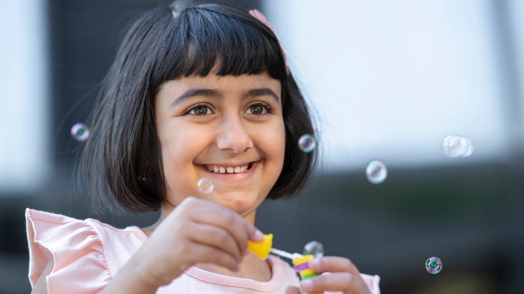 happy girl blows bubbles